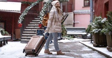 femme en vacances avec sa valise pendant les fêtes de noel